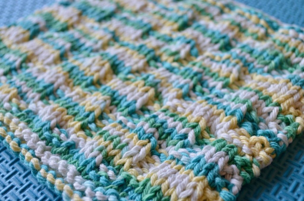 Knitted dishcloth that was taken at an angle to show details of the knit and purl stitches.